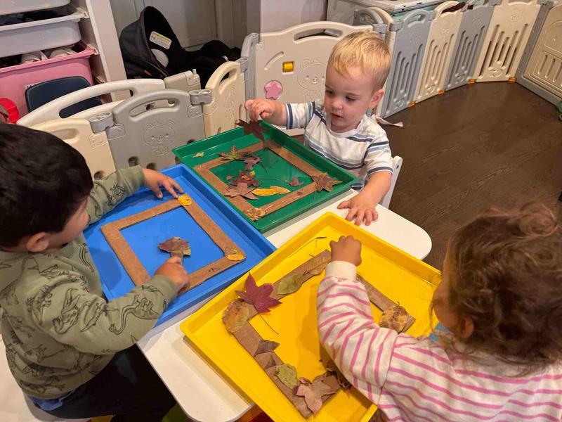 Three children doing leaf art craft