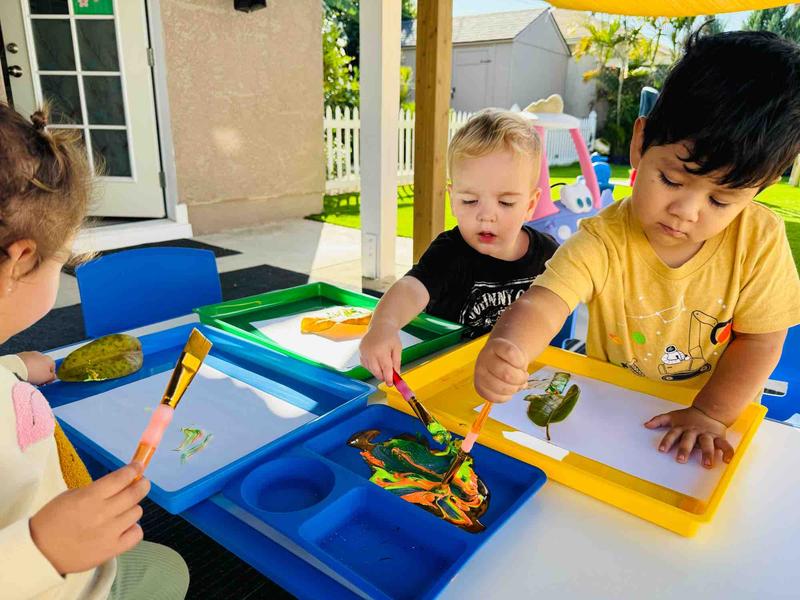 Children painting outdoors at Nice Time Daycare